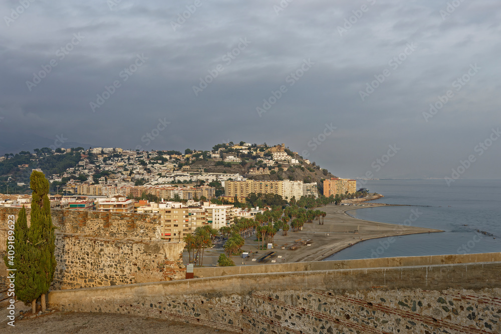The view from the partially restored Fort and City walls of the Citadel at the small Spanish Coastal town of Almunica with Rain Clouds above.