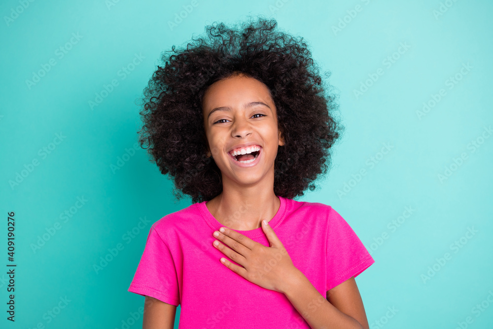 Photo portrait of laughing black skin girl touching chest with one hand isolated on vivid cyan colored background Photo portrait of laughing black skin girl touching chest with one hand isolated on vivid cyan colored background