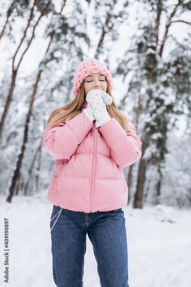 Happy cheerful caucasian girl walking in winter snowy park. Beautiful happy young girl posing outdoors Happy cheerful caucasian girl walking in winter snowy park. Beautiful happy young girl posing outdoors