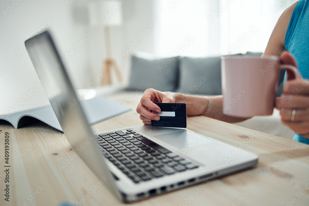 Woman holding credit card and purchasing online with modern laptop. Woman holding credit card and purchasing online with modern laptop.