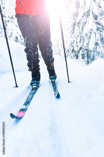 Cross-country skiing. Person in motion through a skiing slope in a winter wonderland on a bright sunny day. photo