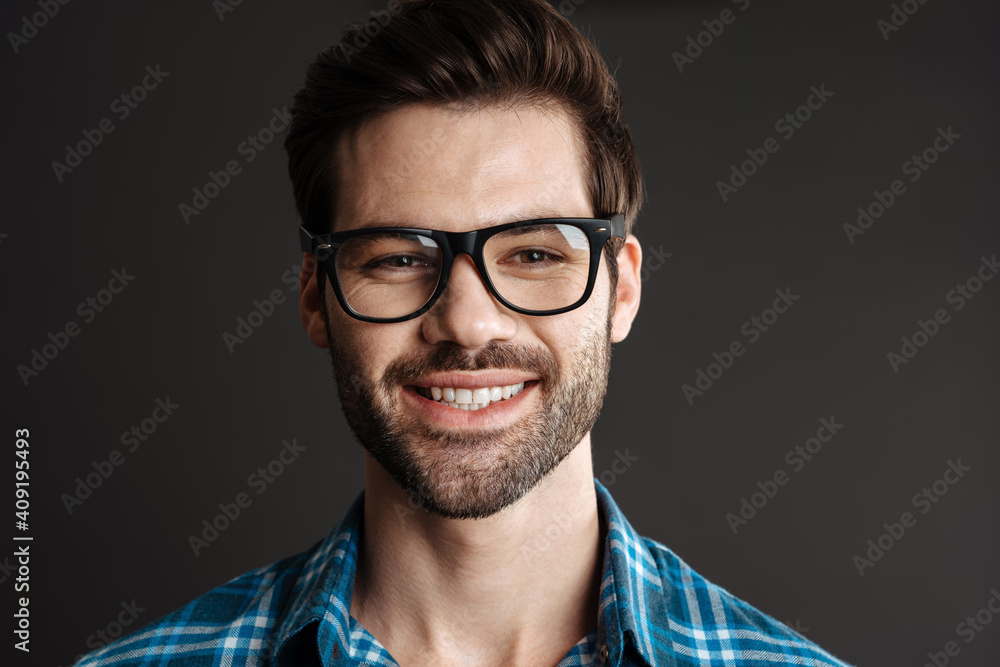 Smiling brutal guy in eyeglasses posing on camera Smiling brutal guy in eyeglasses posing on camera