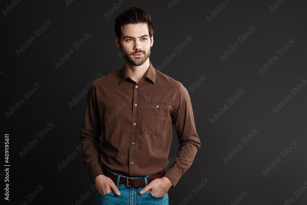 Obraz premium Pleased handsome unshaven guy posing and looking aside