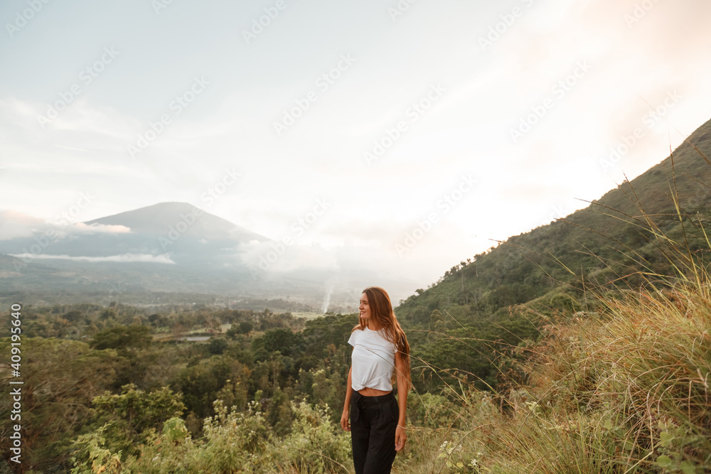 A woman looks at a mountain, a volcano. Rear view. Bali. Agung.