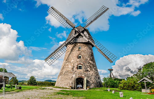 Rural or rustic landscape with old windmill and clouds