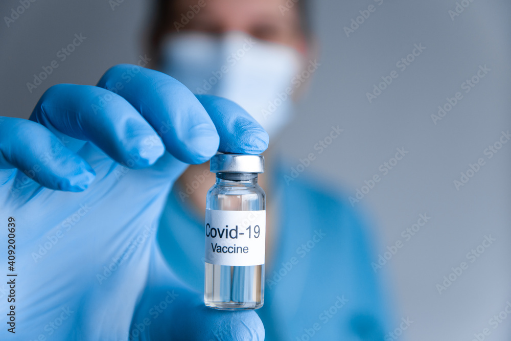 Doctor in rubber gloves holding coronavirus COVID-19 vaccine. Healthcare And Medical concept. Close up Doctor in rubber gloves holding coronavirus COVID-19 vaccine. Healthcare And Medical concept. Close up