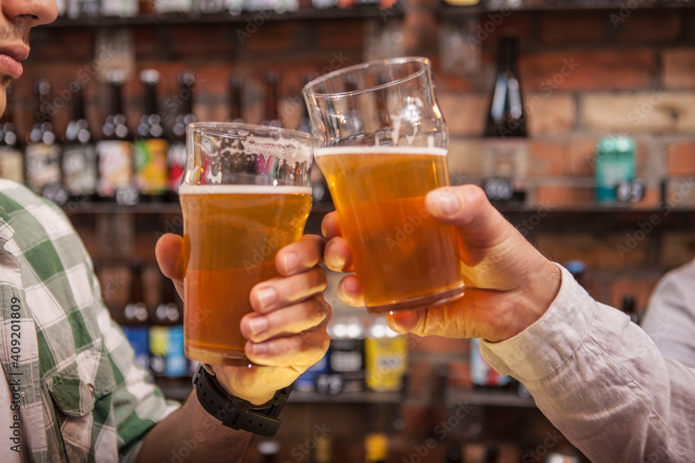Unrecognizablemen clinking beer glasses Unrecognizablemen clinking beer glasses