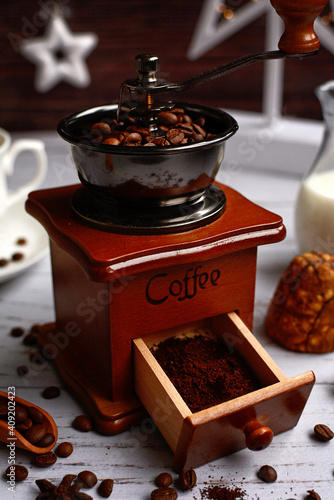 Close- up of wooden vintage coffee grinder with coffee grains. Vertical.