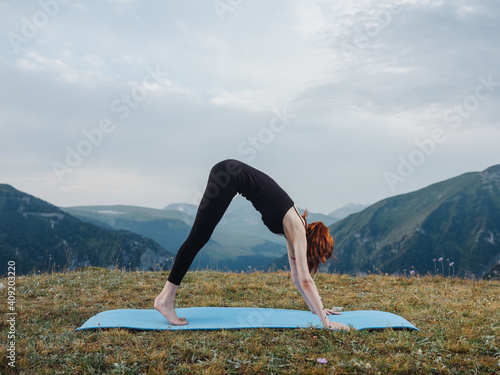 Woman doing yoga exercise mat for fitness nature fresh air mountains