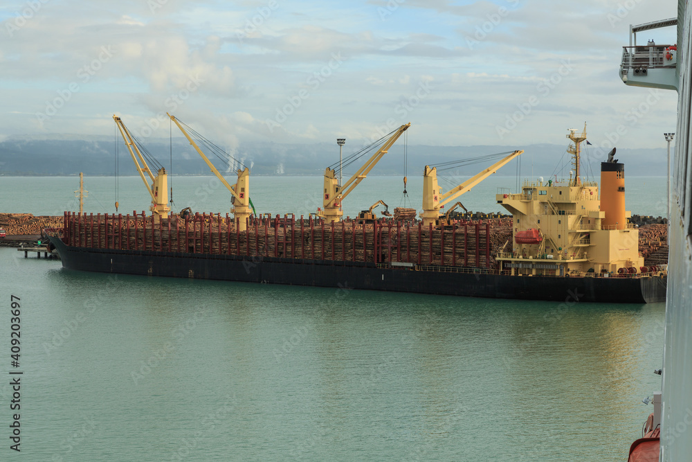 Fototapeta premium A bulk carrier ship in port, taking on a cargo of pine logs