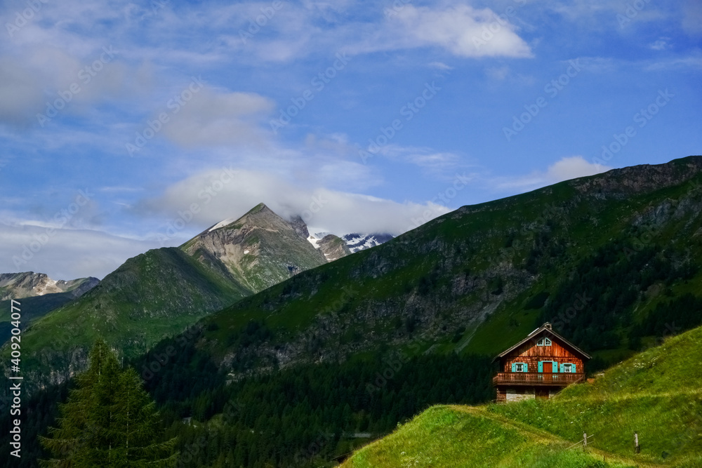 colorful mountain hut in green mountains while hiking