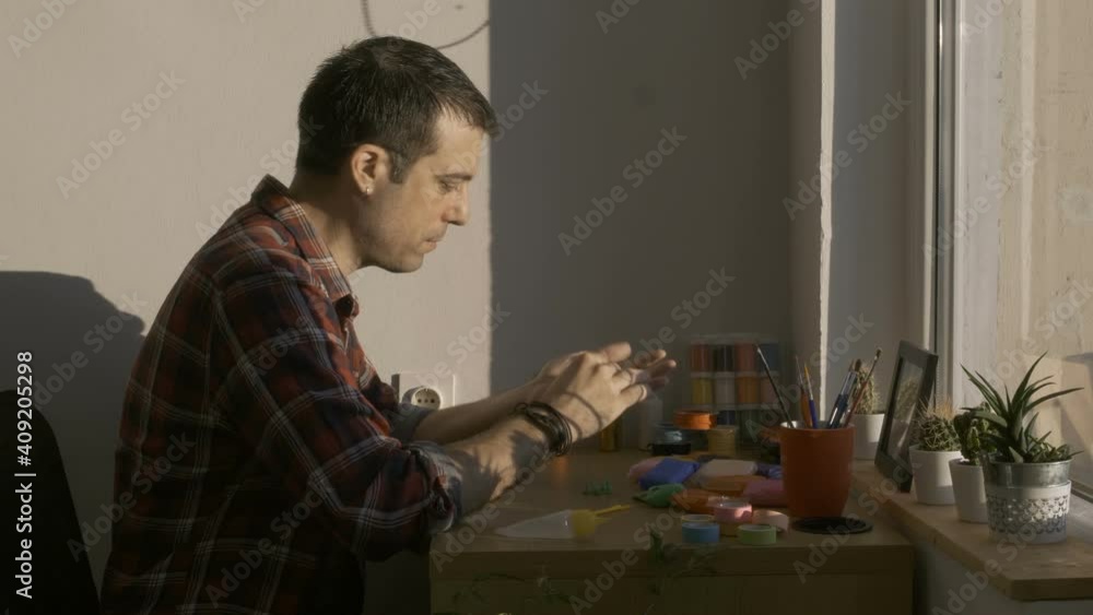 Man at home playing with clay molding shapes Man at home playing with clay molding shapes