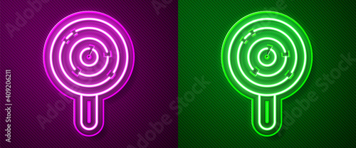 Glowing neon line Lollipop icon isolated on purple and green background. Candy sign. Food, delicious symbol. Vector.