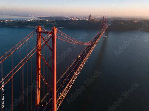 Fototapeta Naklejka Na Ścianę i Meble -  Aerial panorama view over the 25 de Abril Bridge. The bridge is connecting the city of Lisbon to the municipality of Almada on the left bank of the Tejo river, Lisbon
