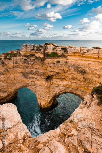 Heart-shaped cliffs on the shore of Atlantic ocean in Algarve, Portugal. Selective focus. Beautiful summer landscape.
