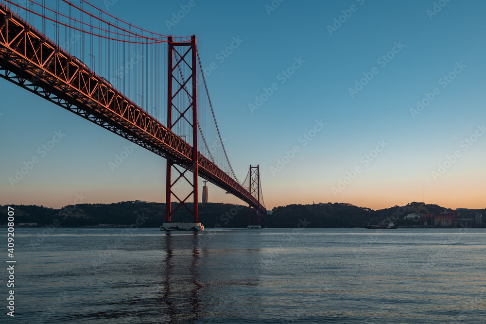 Panorama view over the 25 de Abril Bridge. The bridge is connecting the city of Lisbon to the municipality of Almada on the left bank of the Tejo river, Lisbon Panorama view over the 25 de Abril Bridge. The bridge is connecting the city of Lisbon to the municipality of Almada on the left bank of the Tejo river, Lisbon