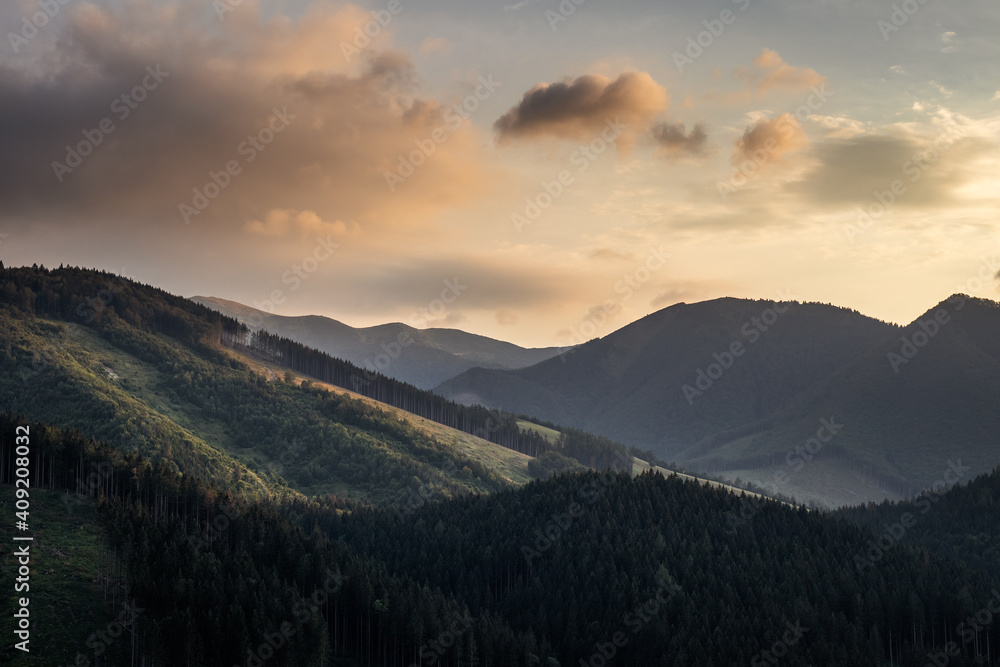 Mountains during sunset. Tourist resort and natural park Mala Fatra, Slovakia. View from mountain peak knows as Boboty. Sky with beautiful clouds