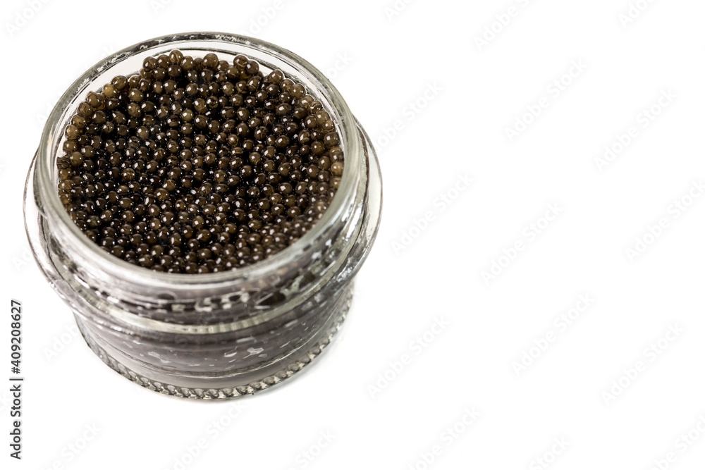 A glass jar with black caviar of premium beluga sturgeon fish on a white homogeneous background. A glass jar with black caviar of premium beluga sturgeon fish on a white homogeneous background.