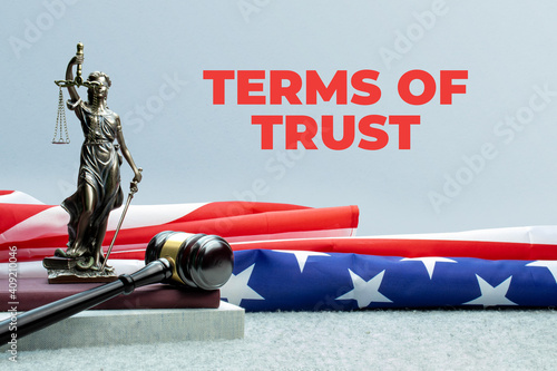 Terms of Trust. Lady justice, judge gavel and books in front of a usa flag. Red text on gray background. 