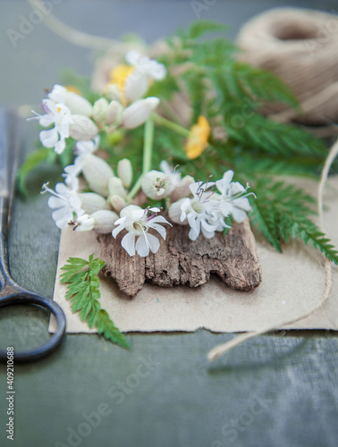 Old tailor scissors, rope and flowers on the wooden background