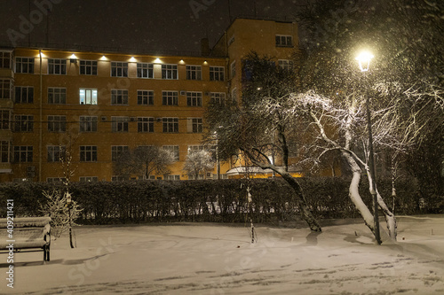 city park on a winter night, beautiful decorative lighting, strong cold snowstorm without people