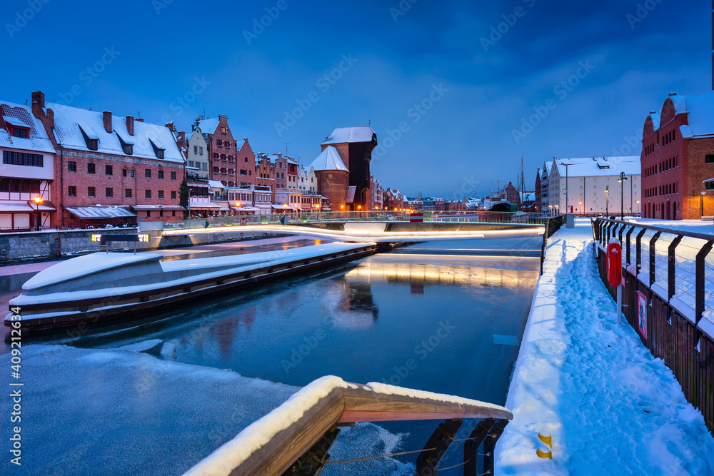 Medieval port crane in Gdansk at Motlawa river in snowy winter, Poland