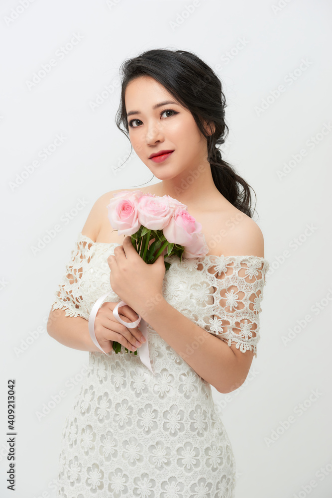 Gorgeous young bride with a rose bouquet isolated against white background. Gorgeous young bride with a rose bouquet isolated against white background.
