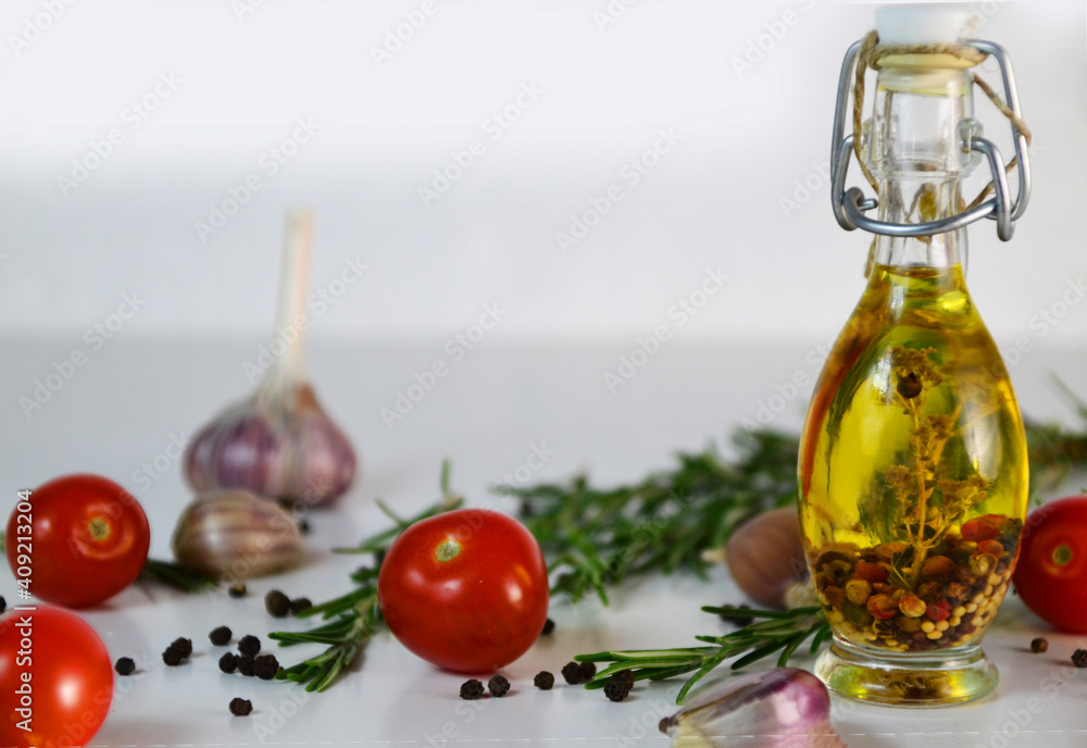 Fresh olives and oil in bottle with rosemary on white background with scattered cherry tomatoes end spicies, top view. Organic olive oil concept Fresh olives and oil in bottle with rosemary on white background with scattered cherry tomatoes end spicies, top view. Organic olive oil concept