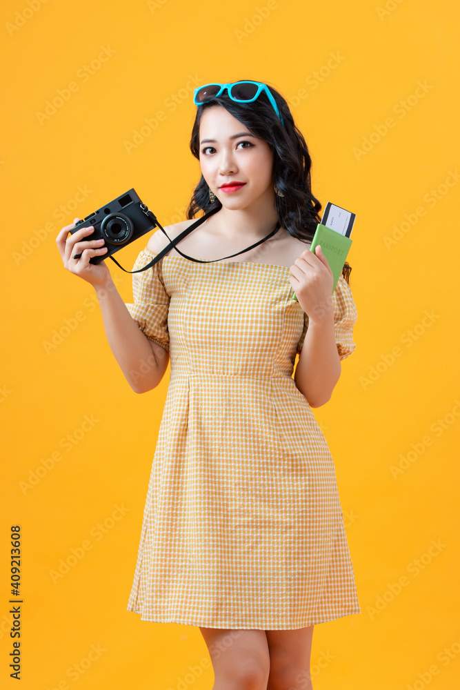 Happy asian woman tourist holding passport isolated on yellow background Happy asian woman tourist holding passport isolated on yellow background