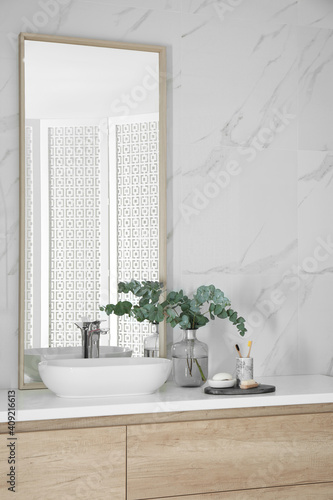 Modern bathroom interior with large mirror and vessel sink