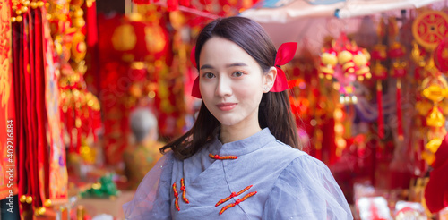 Asian beautiful woman in long hair wears a grey Chinese dress with Chinese new year theme.