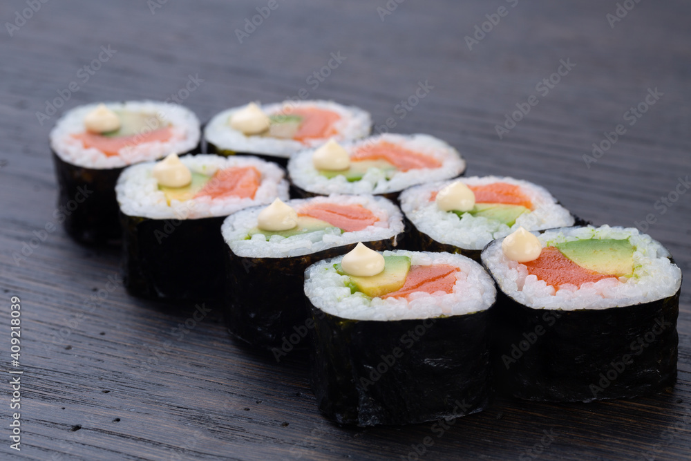 traditional Japanese sushi with salmon, soft cheese, avocado and red caviar, garnished with creamy sauce. Japanese kitchen. Japanese restaurant traditional Japanese sushi with salmon, soft cheese, avocado and red caviar, garnished with creamy sauce. Japanese kitchen. Japanese restaurant