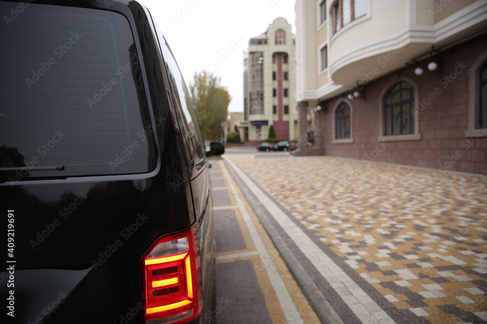 Black delivery van parked on street near building