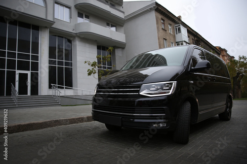 Black delivery van parked on street near building