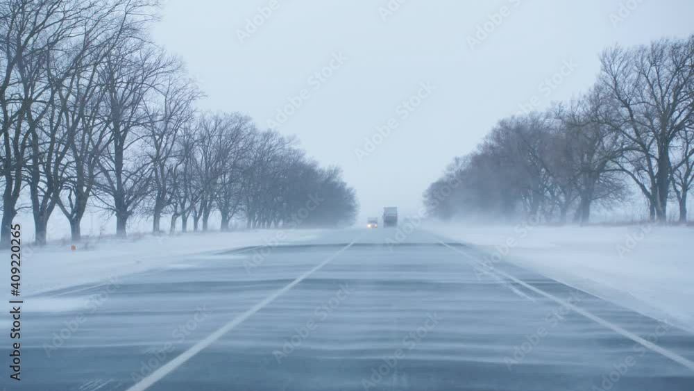The view from the car driving on the highway through the snow drifts blizzard. The view from the car driving on the highway through the snow drifts blizzard.