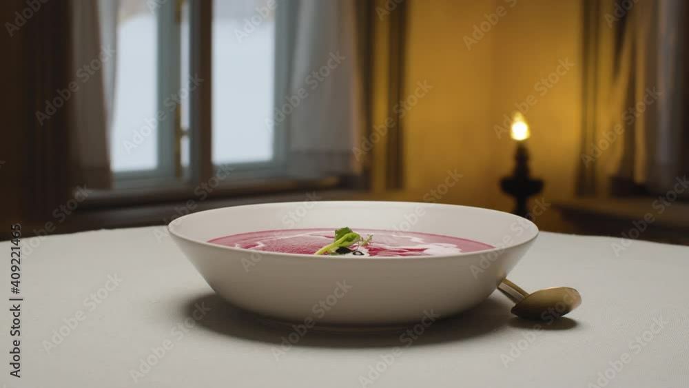 Close up plate of ready-made beet cream soup in restaurant. Camera flying around the table. Rotation Close up plate of ready-made beet cream soup in restaurant. Camera flying around the table. Rotation