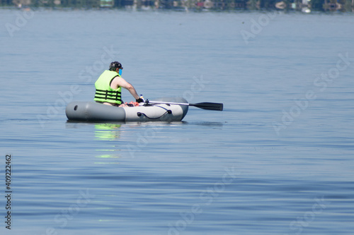 The coach of young yachtsmen sits in a rubber inflatable boat and watches the training