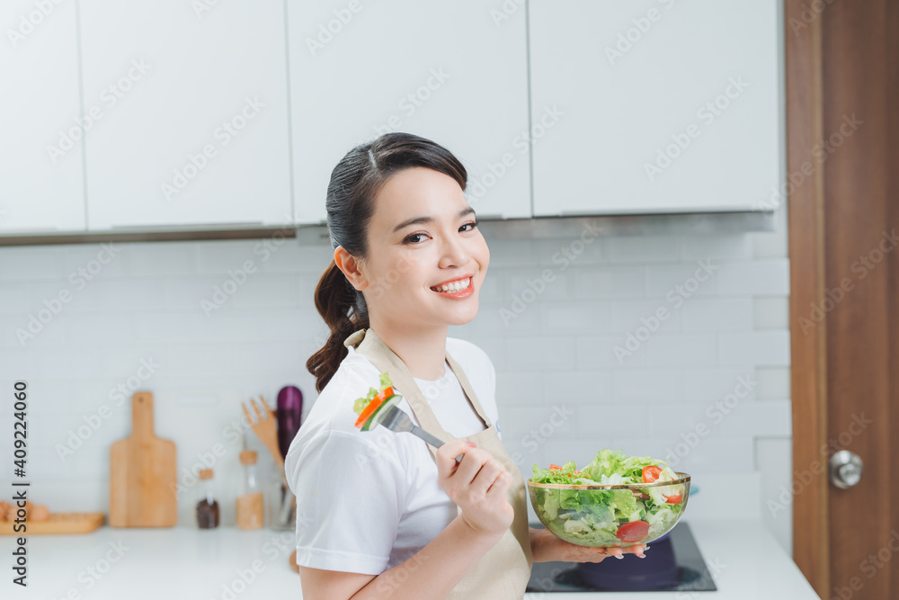 Young woman eating salad and holding a mixed Young woman eating salad and holding a mixed