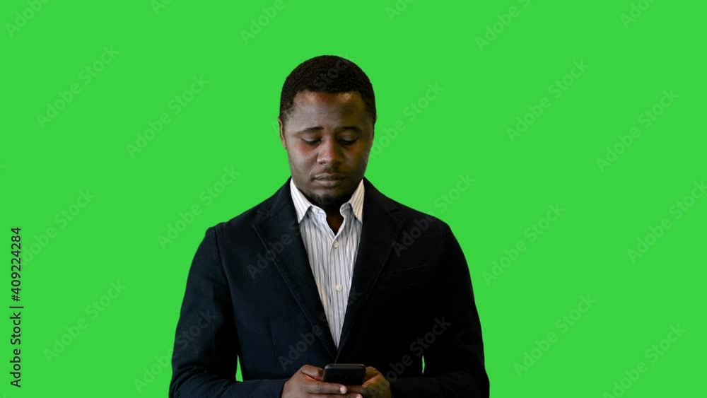 Determined African American businessman texting on a Green Screen, Chroma Key. Determined African American businessman texting on a Green Screen, Chroma Key.