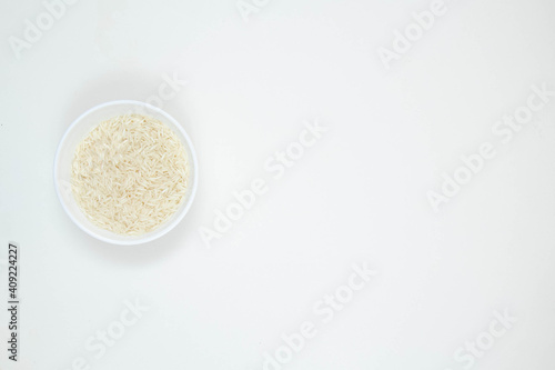 Bowl of long grain white rice, isolated on white background. Copy space.