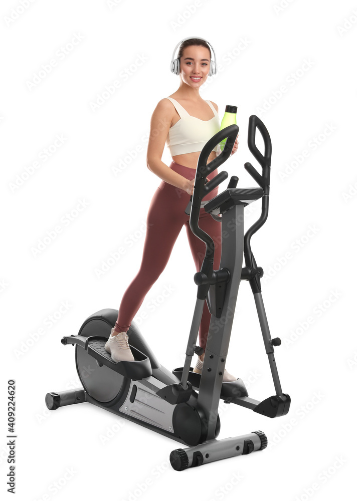Woman with bottle using modern elliptical machine on white background Woman with bottle using modern elliptical machine on white background