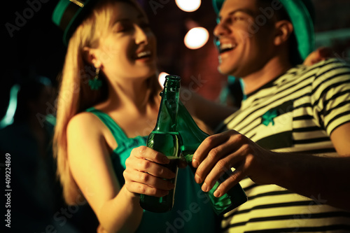 Couple with beer celebrating St Patrick's day in pub, focus on hands