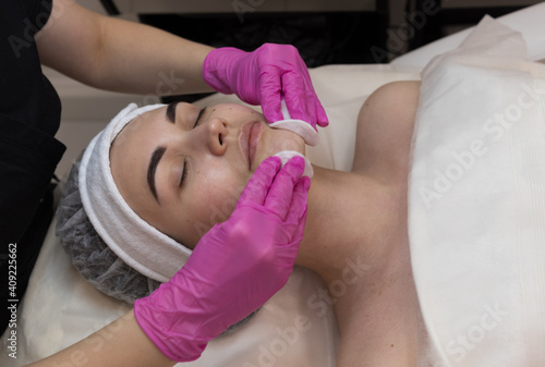 A young girl at a cosmetologist appointment. Facial treatments, professional skin cleansing