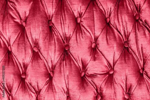 Quilted sofa background. Red color fabric texture. Luxury furniture pattern.