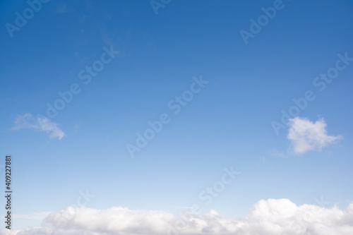 青い空、日光を受ける白い雲。