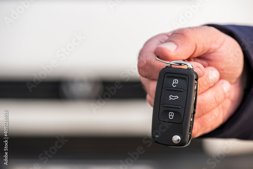 Man hand holding a car key. New car sell, auto showroom, car sale deal concepts. Black car key.