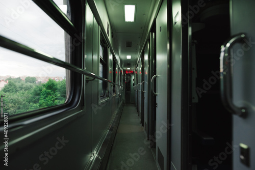 Empty train corridor with compartment in the evening. Trains on the road. Travel by train concept.