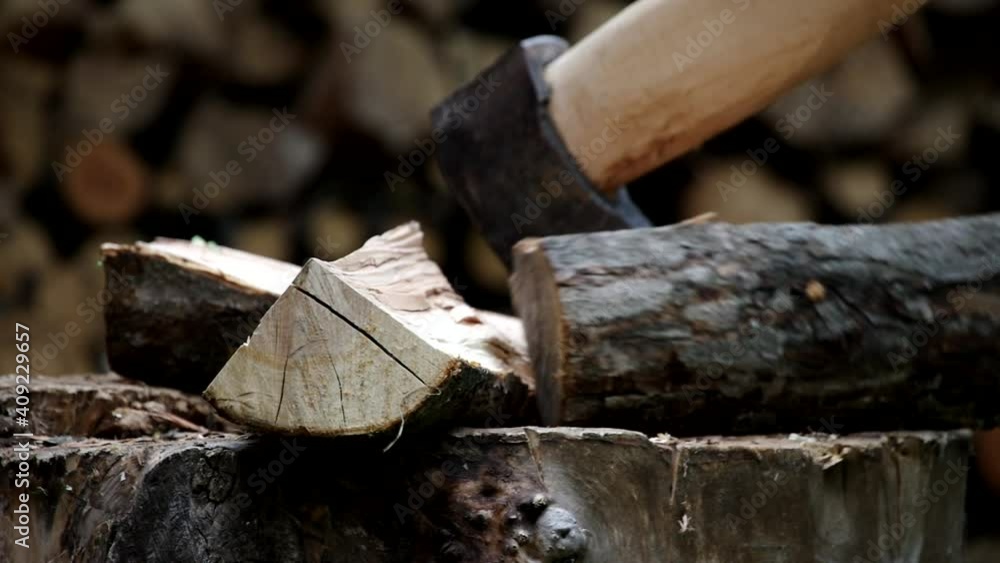 Splitting firewood with an axe. Cutting logs, harvesting firewood for the winter Splitting firewood with an axe. Cutting logs, harvesting firewood for the winter