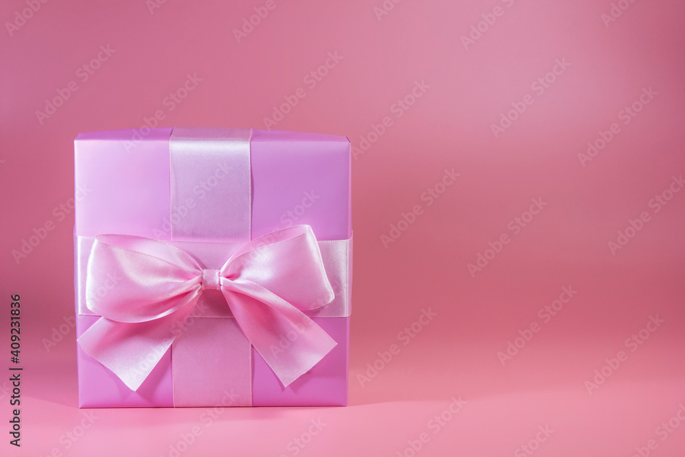 Gift box with a bow on a pink background Gift box with a bow on a pink background