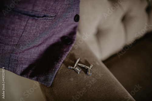 Grooms morning preparation. Handsome man getting dressed and preparing for the wedding, businessman checking time on his wrist watch, man putting clock on hand, groom getting ready in the morning photo